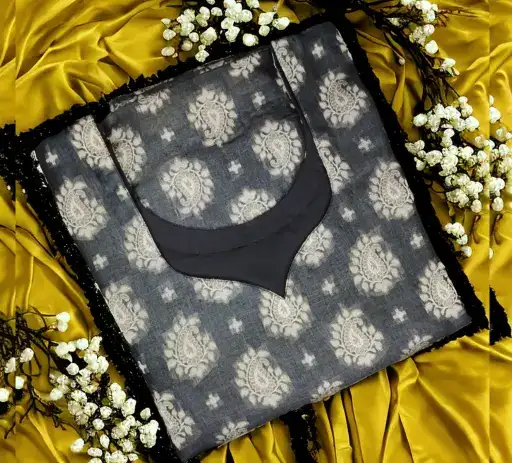 Elegant grey patterned kurta featuring intricate white paisley motifs, bordered with black lace and highlighted by a striking solid black designer neckline. This custom-stitched ladies suit top is beautifully arranged on a golden yellow fabric with delicate white floral accents, showcasing the premium women's boutique tailoring and custom stitching services offered by Tailorboutiques.com in Greater Noida