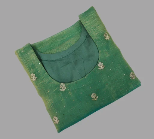 Close-up view of an elegantly crafted, neatly folded green women's kurti featuring a beautifully finished wide neckline, delicate floral zari embroidery, and subtle sequin detailing. This premium custom-stitched garment exemplifies the high-quality ethnic wear and flawless finish delivered through the seamless doorstep ladies' tailoring process at Tailorboutiques.com.